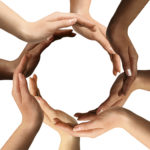 Conceptual symbol of multiracial human hands making a circle on white background with a copy space in the middle